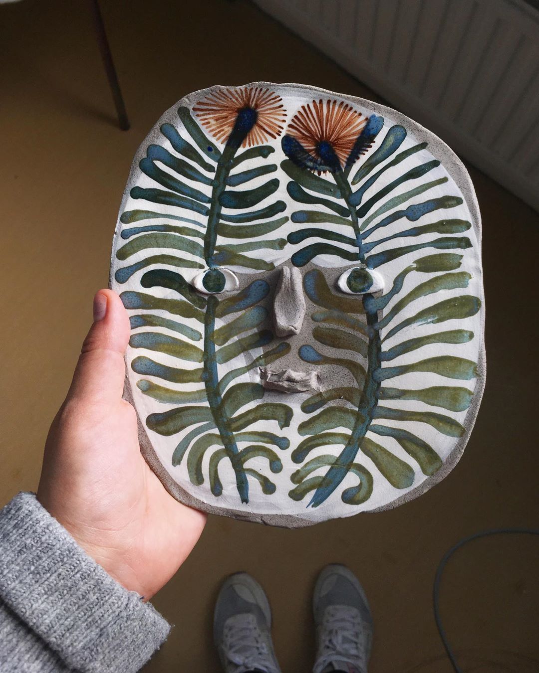 Ceramic face with flower motif