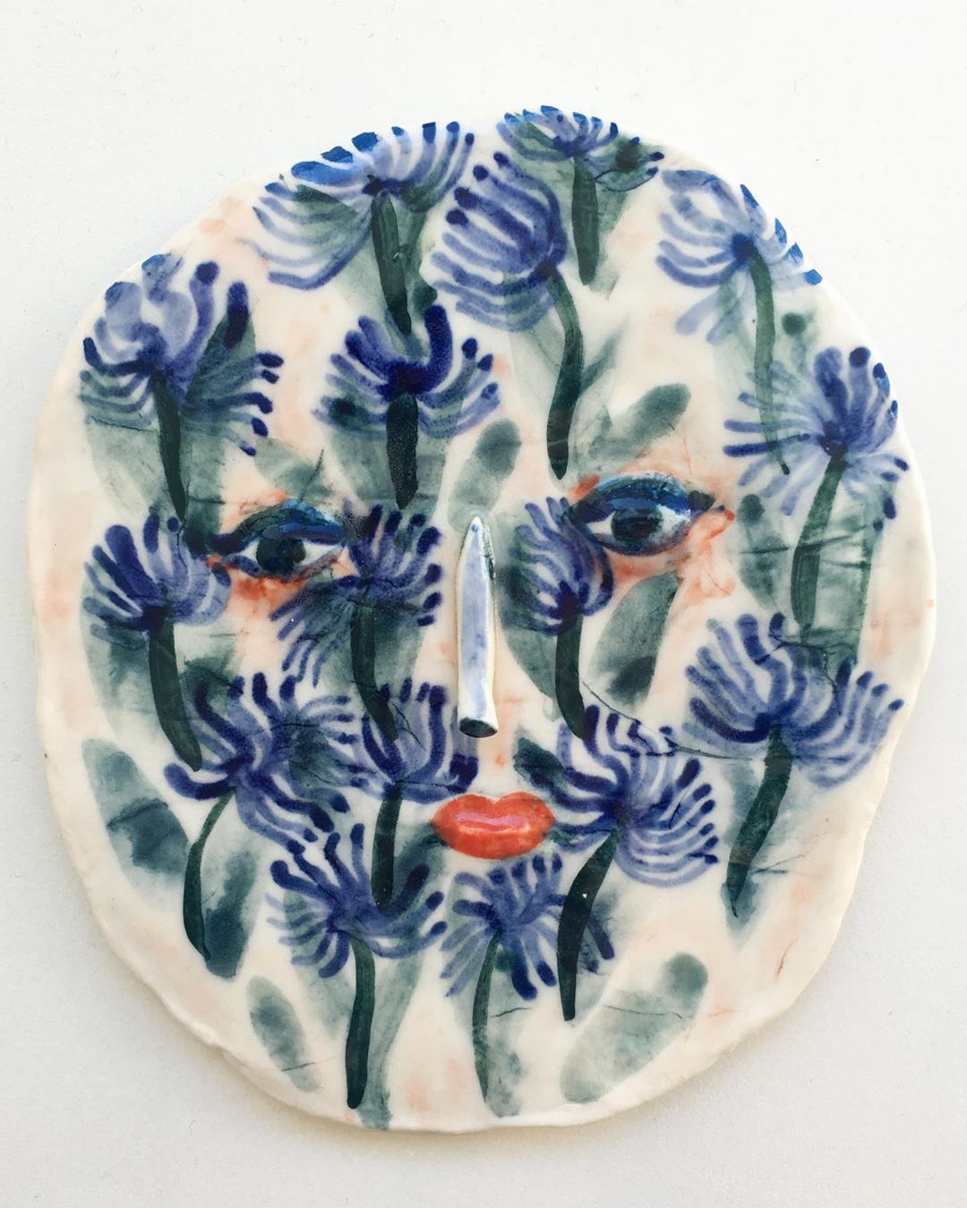 Ceramic face with flower motif