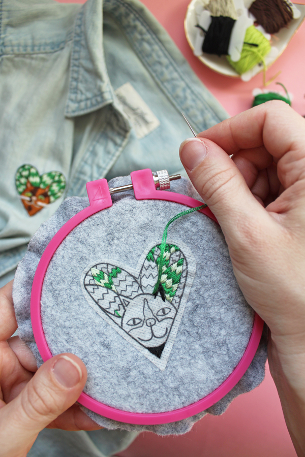 Free embroidery pattern of a cat surrounded by snake plant leaves