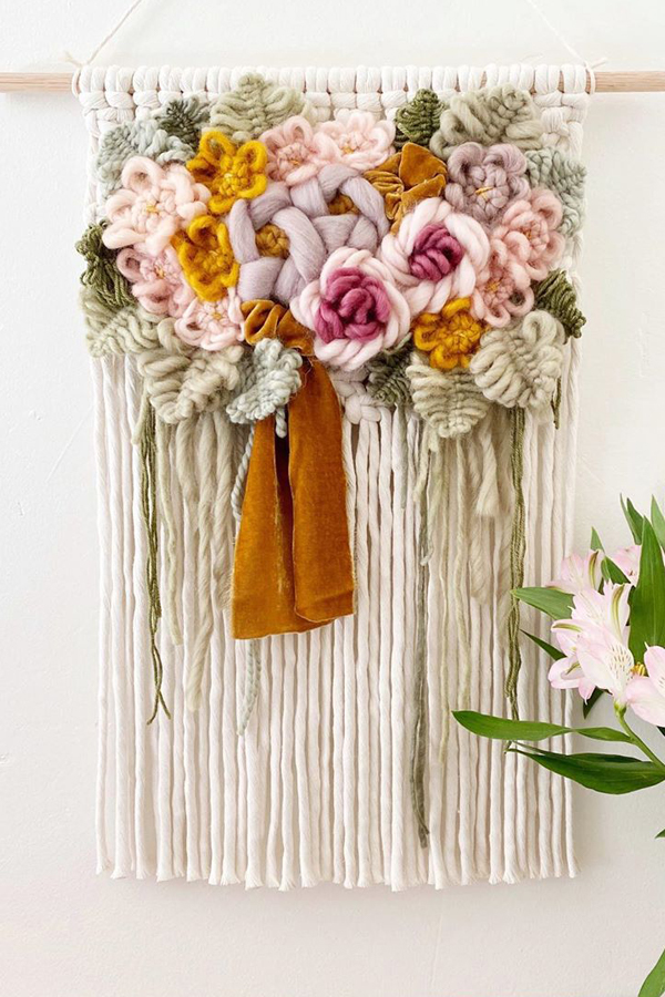 Modern macrame wall hanging with yarn flowers