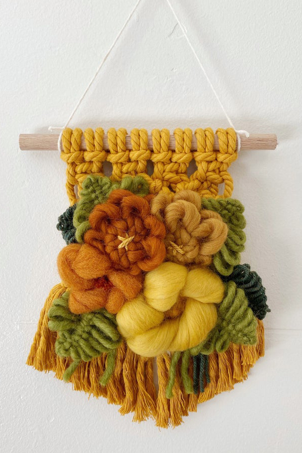 Modern macrame wall hanging with yarn flowers