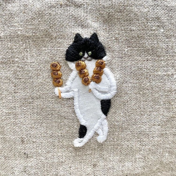 Embroidery of a Cat Carrying a Sushi